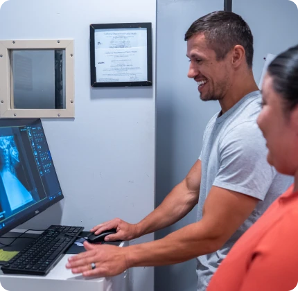 Dr. Michael VanDerschelden reviewing a patient's digital X-ray and PostureRay analysis on screen