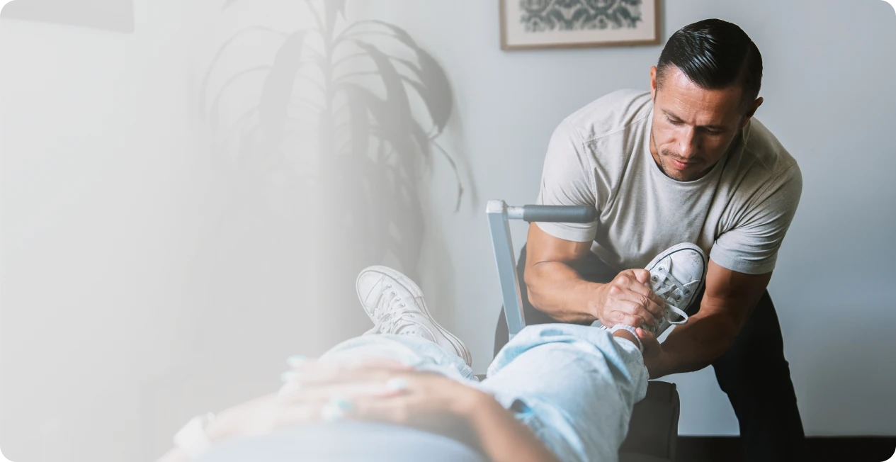 Dr. Michael VanDerschelden comparing leg length on a patient lying on the treatment table at Huntington Beach Chiropractic