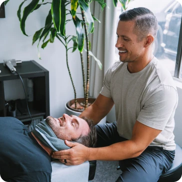 Dr. Michael VanDerschelden, DC cradling the head and neck of a patient lying on the treatment table