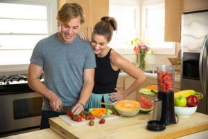 couple cutting fruit in kitchen